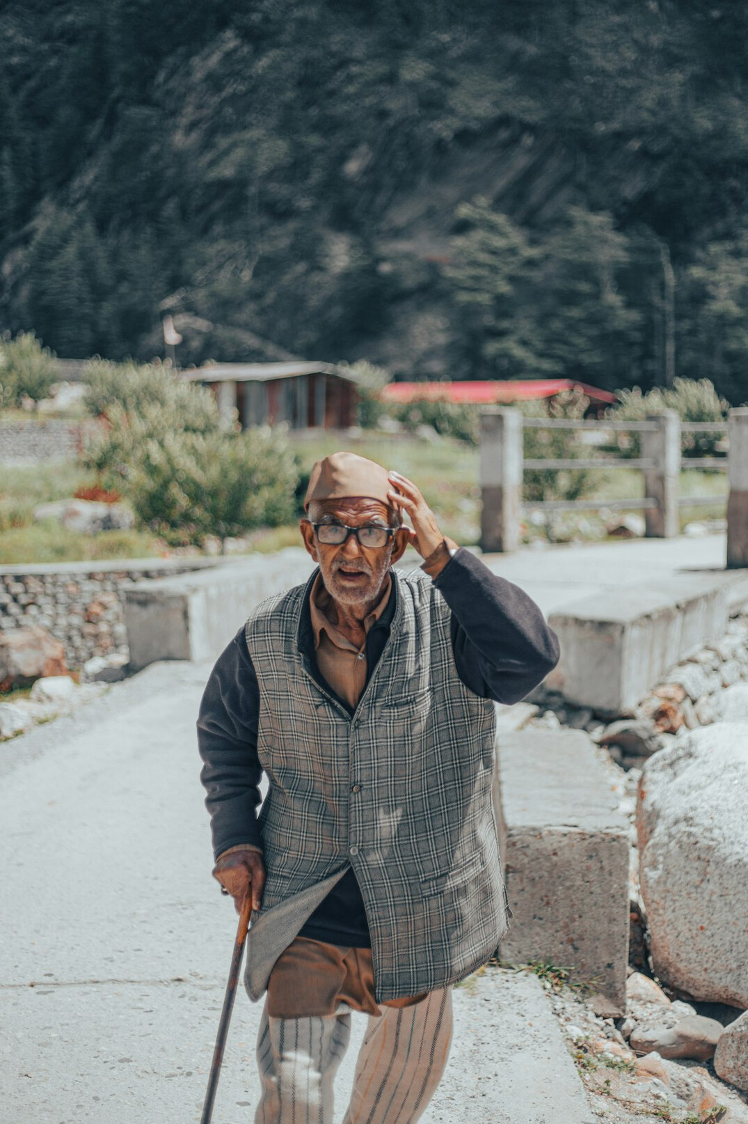 Portrait of a cheerful elderly man with glasses and a cardigan