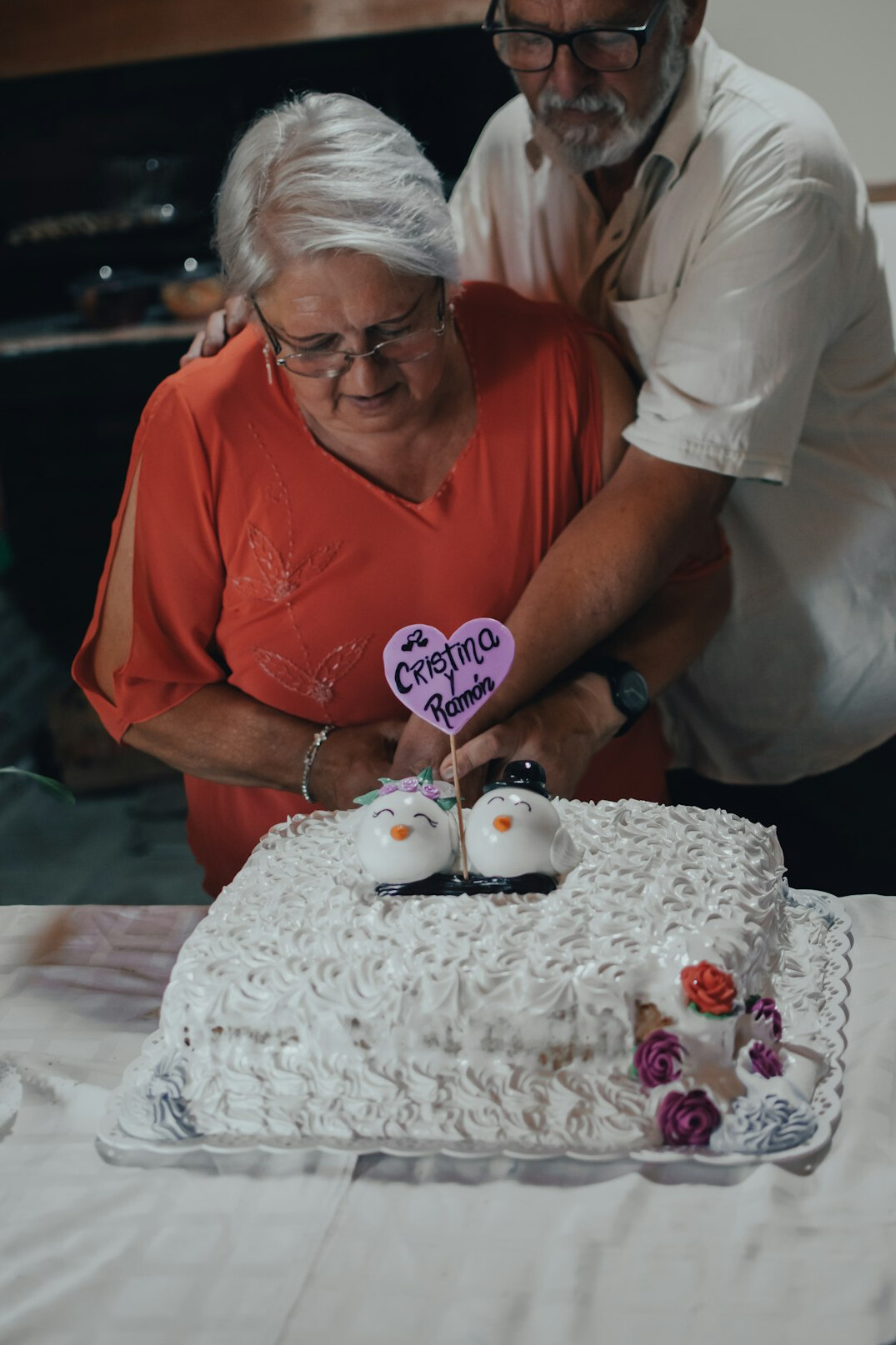 Elderly people celebrating a birthday with a cake around a table